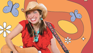 A woman wearing a cowboy hat playing a guitar