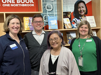 A photo of library staff with author Naomi Hirahara