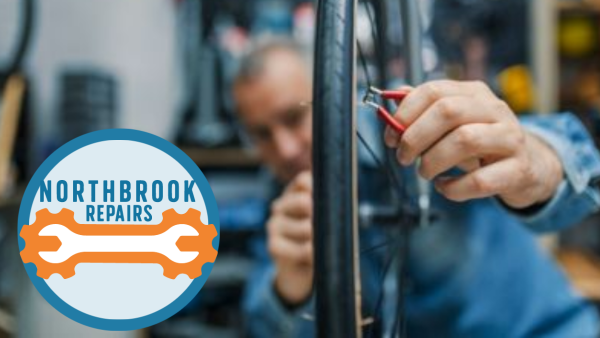 A photo of a man repairing a bike